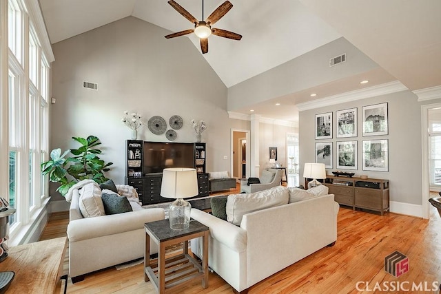 living room with light wood-style floors, plenty of natural light, a ceiling fan, and visible vents