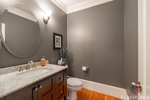 bathroom featuring vanity, crown molding, toilet, and wood finished floors