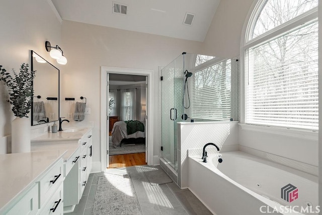 ensuite bathroom featuring a bath, visible vents, a shower stall, and vanity