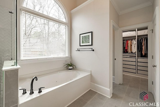 bathroom with tile patterned flooring, a walk in closet, crown molding, a garden tub, and a wealth of natural light