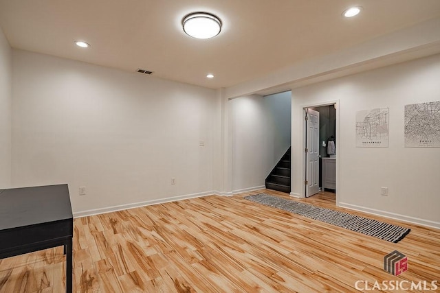 unfurnished room featuring light wood-type flooring, visible vents, recessed lighting, baseboards, and stairs