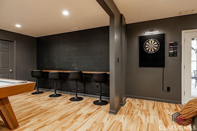 interior space featuring visible vents, recessed lighting, a bar, and wood finished floors