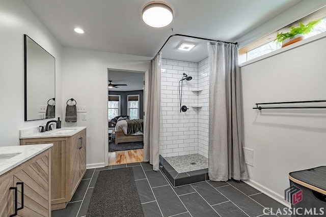 ensuite bathroom featuring vanity, a wealth of natural light, ensuite bathroom, and a tile shower