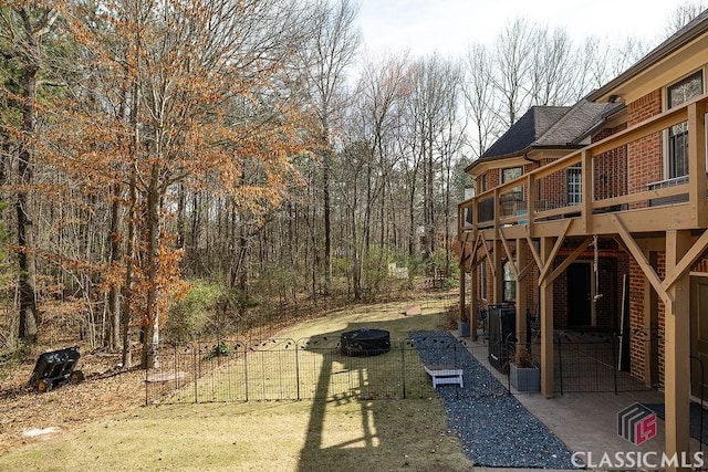 view of yard featuring a deck and an outdoor fire pit