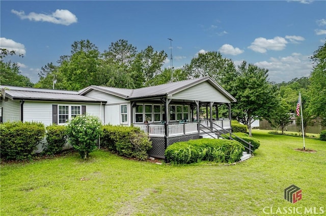 rear view of property with metal roof and a yard