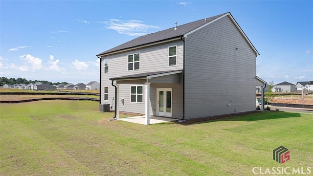 rear view of house featuring a patio, central AC, french doors, and a yard