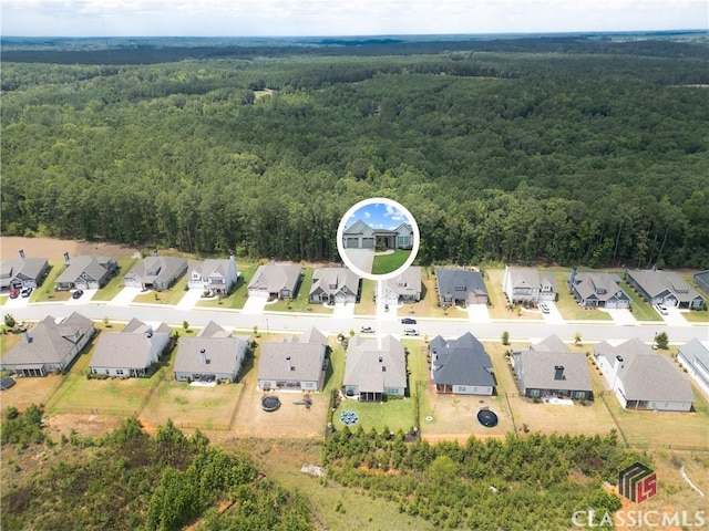 drone / aerial view with a forest view and a residential view