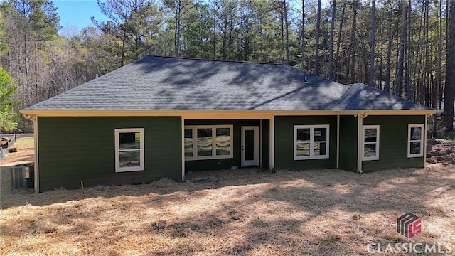 2850 Caboose Ct, Greensboro, GA 30642 - view of front of house featuring a view of trees, a shingled roof, and central AC unit