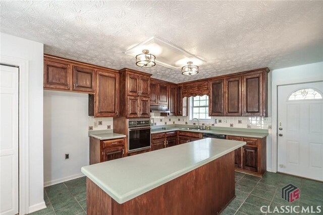 1050 Eugene Ln, Madison, GA 30650 - kitchen featuring light countertops, dark tile patterned floors, a sink, black oven, and backsplash