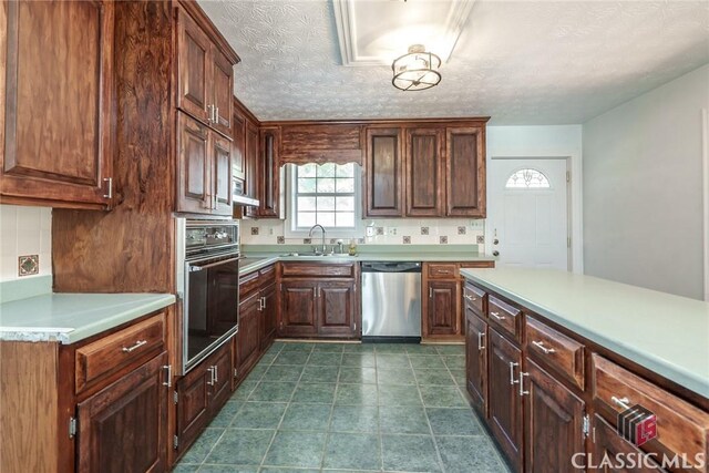 1050 Eugene Ln, Madison, GA 30650 - kitchen featuring light countertops, a sink, backsplash, stainless steel dishwasher, and oven