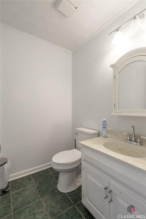 1050 Eugene Ln, Madison, GA 30650 - half bath featuring baseboards, a textured ceiling, toilet, and vanity
