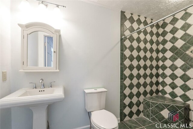 1050 Eugene Ln, Madison, GA 30650 - bathroom featuring a sink, toilet, and tiled shower