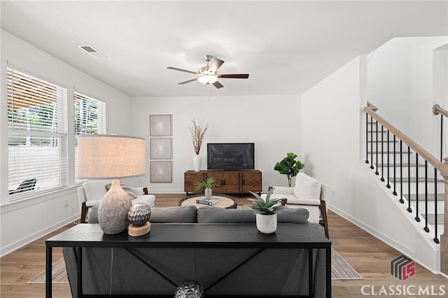 living area with ceiling fan, baseboards, visible vents, and wood finished floors