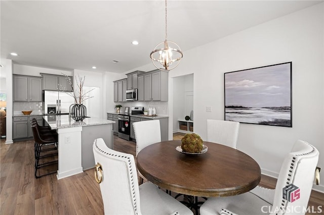 dining room featuring an inviting chandelier, recessed lighting, and wood finished floors