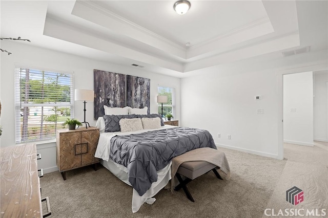 bedroom with light colored carpet, crown molding, visible vents, and a raised ceiling