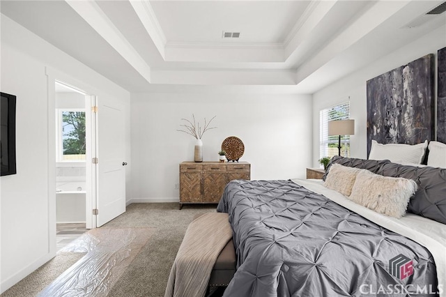 carpeted bedroom with a raised ceiling, ornamental molding, visible vents, and ensuite bathroom