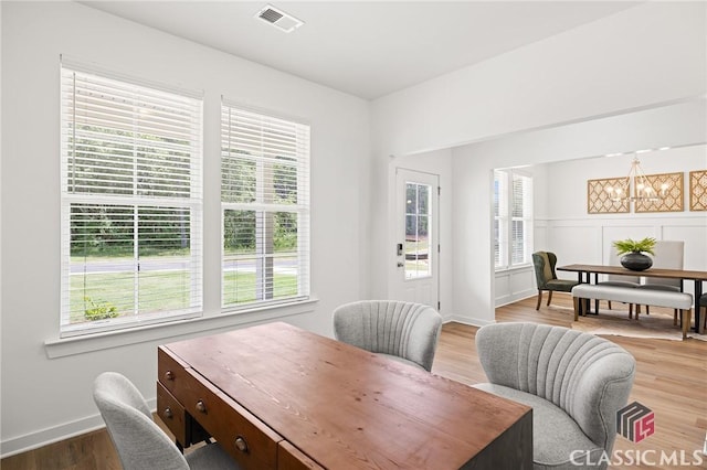 office space featuring baseboards, visible vents, plenty of natural light, and wood finished floors