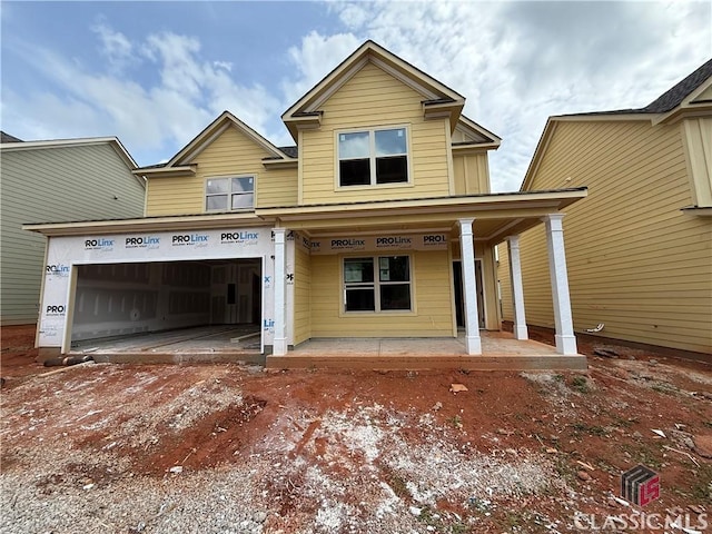 view of front facade with a garage, a porch, and driveway