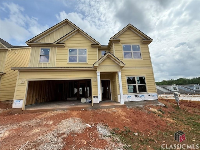 view of front of property featuring board and batten siding, driveway, and a garage