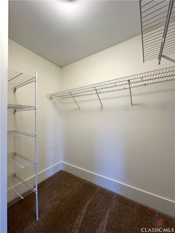 spacious closet with dark carpet