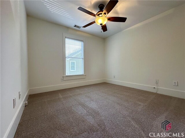carpeted spare room featuring a ceiling fan, baseboards, and visible vents