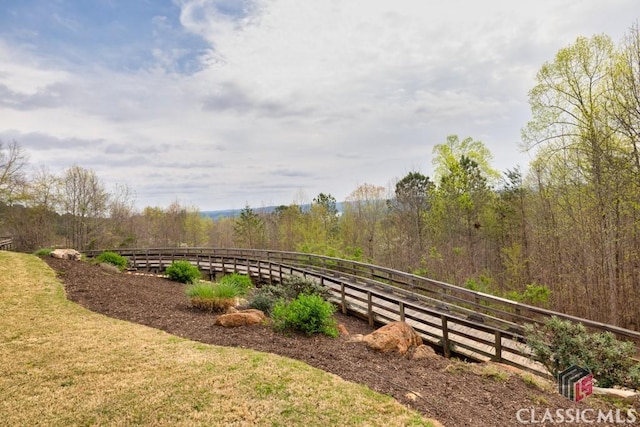view of community featuring fence and a forest view