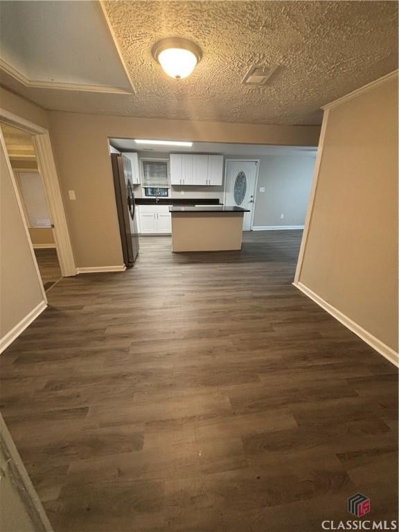 626 Vine St, Athens, GA 30601 - kitchen with freestanding refrigerator, dark countertops, a textured ceiling, dark wood finished floors, and white cabinetry