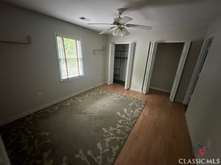 625 Whitehall Rd, Athens, GA 30605 - unfurnished bedroom with two closets, wood finished floors, a ceiling fan, and baseboards