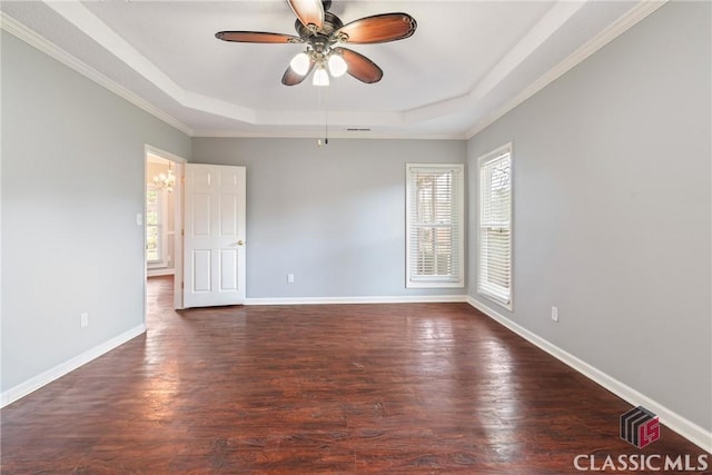 empty room featuring a tray ceiling, baseboards, a ceiling fan, and wood finished floors