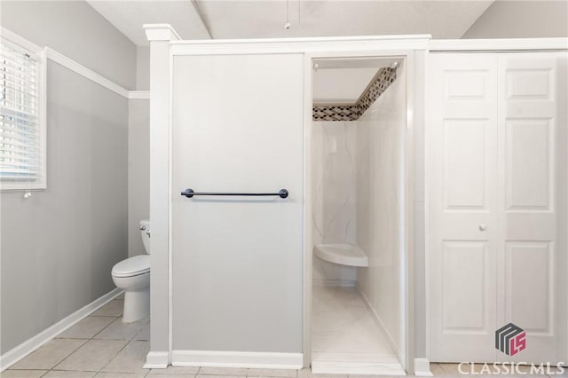 bathroom with toilet, a walk in shower, baseboards, and tile patterned flooring