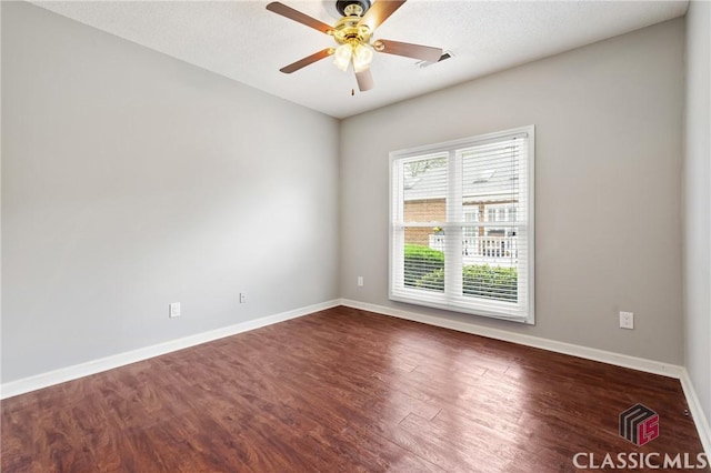 empty room with visible vents, baseboards, ceiling fan, and wood finished floors