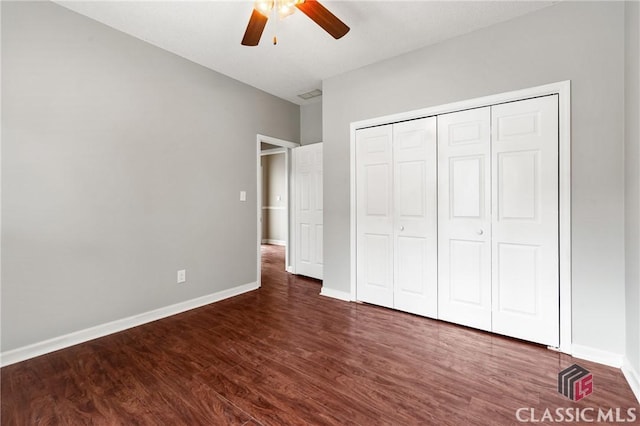 unfurnished bedroom featuring ceiling fan, a closet, baseboards, and wood finished floors