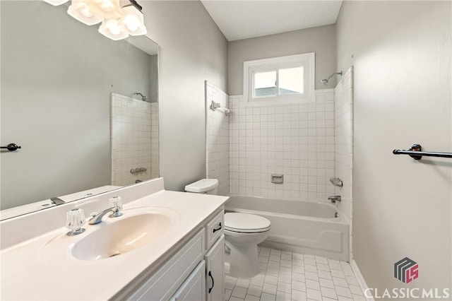 bathroom with toilet, tile patterned floors, vanity, and  shower combination