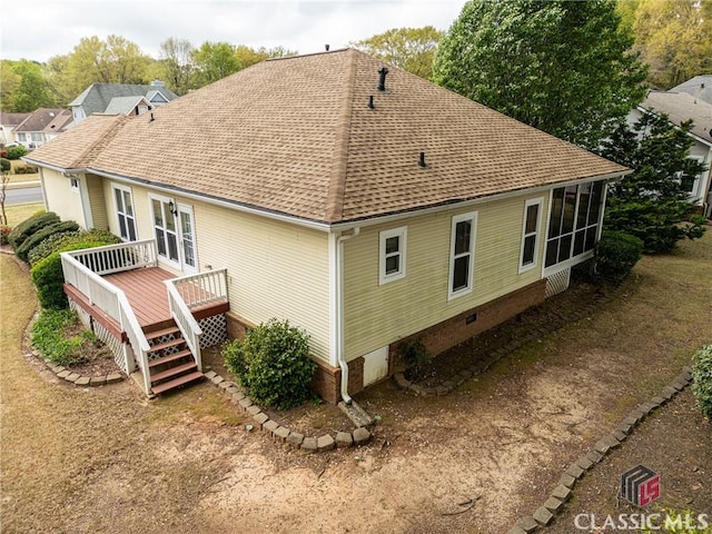 rear view of house featuring a shingled roof, a wooden deck, and crawl space