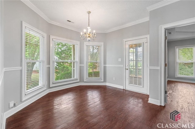 unfurnished dining area featuring a chandelier, a healthy amount of sunlight, wood finished floors, and visible vents