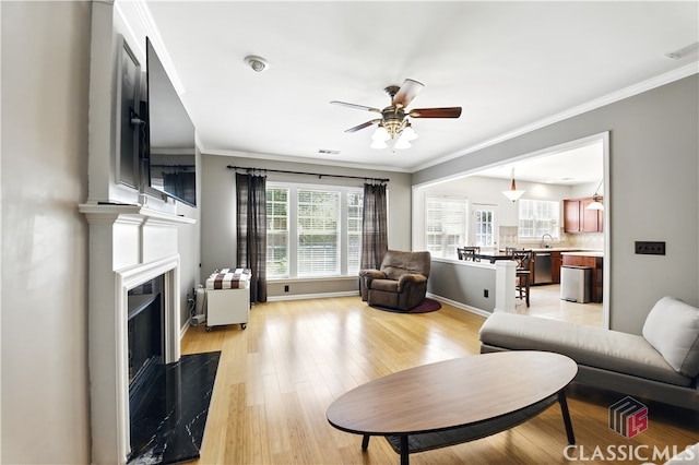 340 Hammersmith Dr, Suwanee, GA 30024 - living area featuring a fireplace, a ceiling fan, light wood-style floors, crown molding, and baseboards