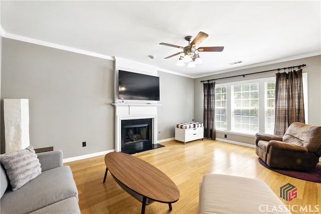 340 Hammersmith Dr, Suwanee, GA 30024 - living room featuring ornamental molding, a ceiling fan, light wood-style flooring, baseboards, and a fireplace with flush hearth