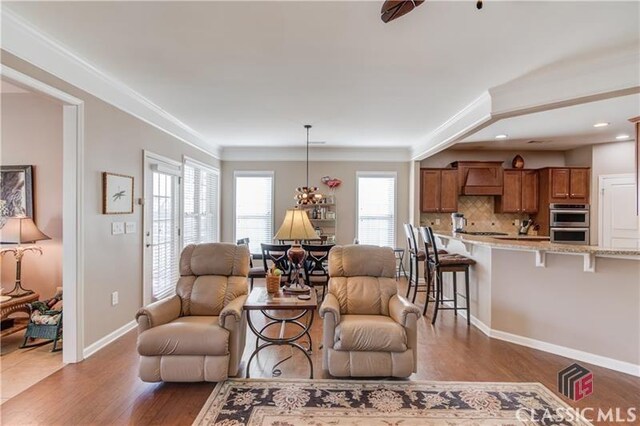 6706 Mill Rock Ct, Hoschton, GA 30548 - living area featuring baseboards, a ceiling fan, ornate columns, and wood finished floors