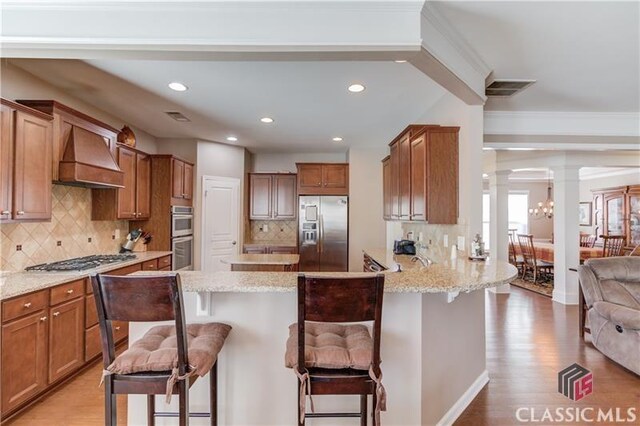 6706 Mill Rock Ct, Hoschton, GA 30548 - kitchen featuring light stone counters, recessed lighting, decorative backsplash, light wood finished floors, and appliances with stainless steel finishes
