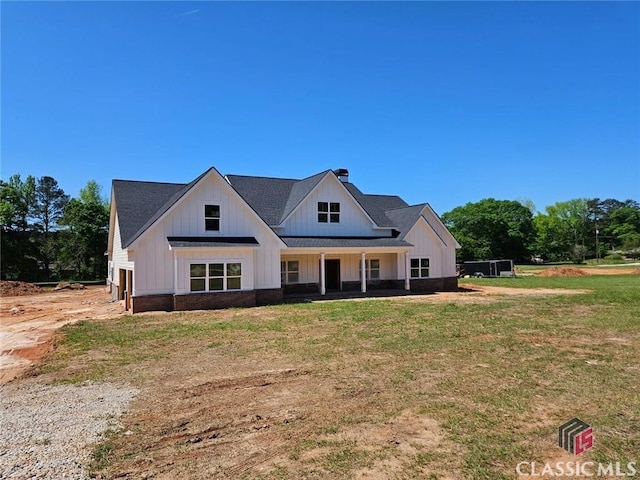 modern farmhouse style home with board and batten siding and a front lawn