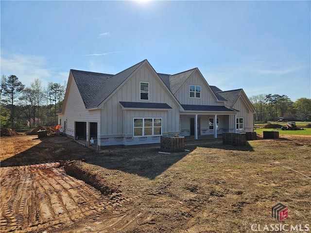 back of house featuring board and batten siding, an attached garage, and driveway