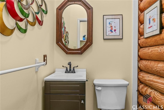 half bathroom with toilet, vanity, and log walls
