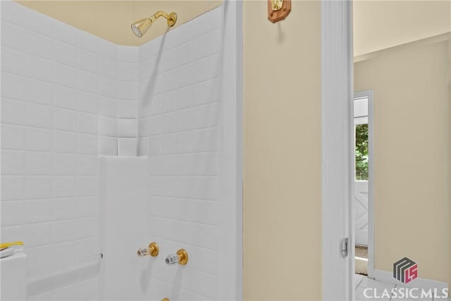 bathroom with tile patterned floors and shower / washtub combination