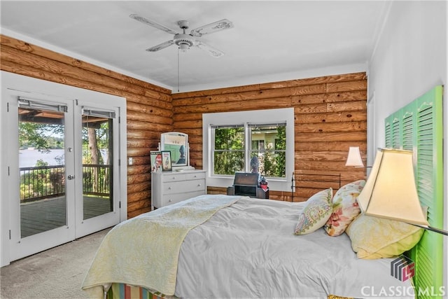 bedroom with access to outside, carpet flooring, and rustic walls
