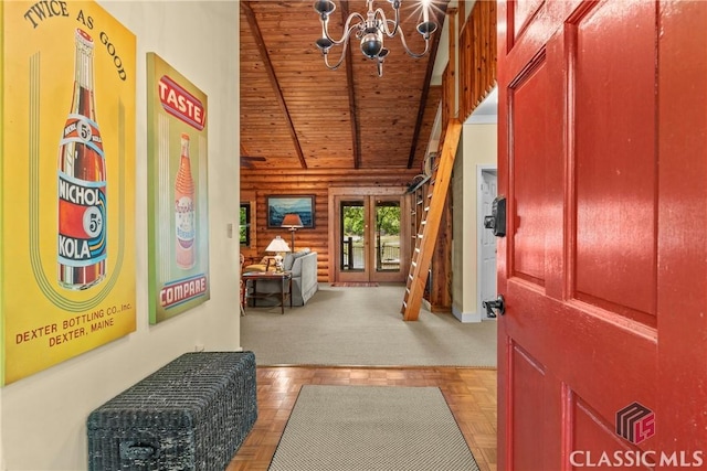 entryway featuring a notable chandelier, wooden ceiling, rustic walls, and lofted ceiling with beams