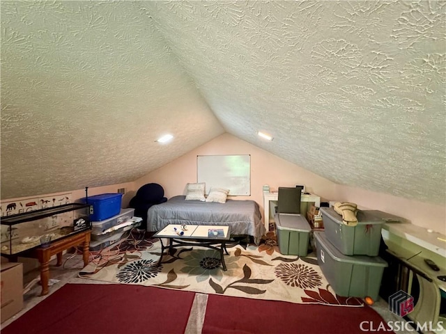bedroom with lofted ceiling and a textured ceiling