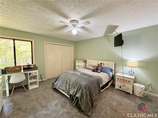 bedroom with a textured ceiling, baseboards, carpet, a ceiling fan, and a closet