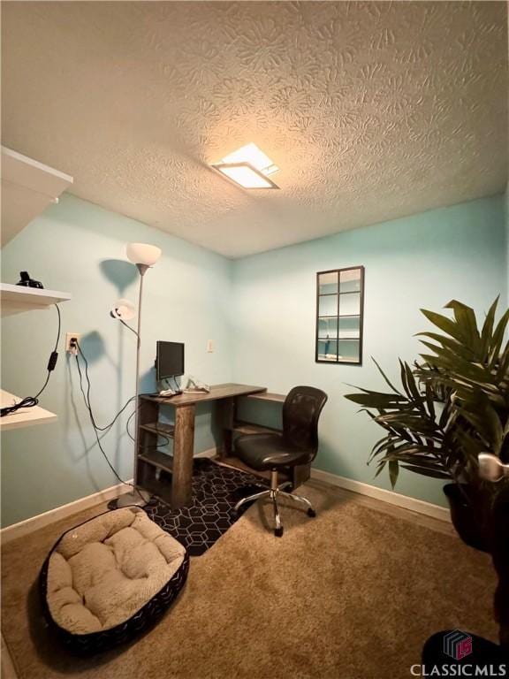 carpeted office featuring a textured ceiling and baseboards