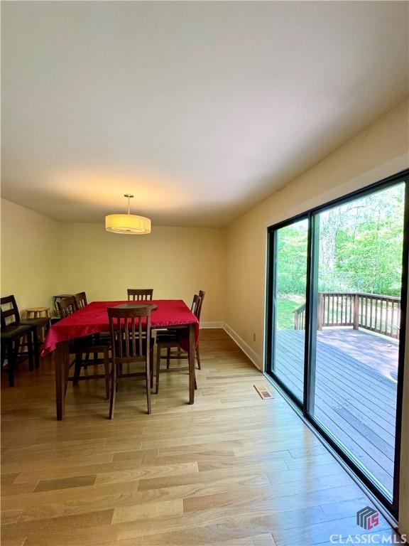dining area with light wood finished floors and baseboards