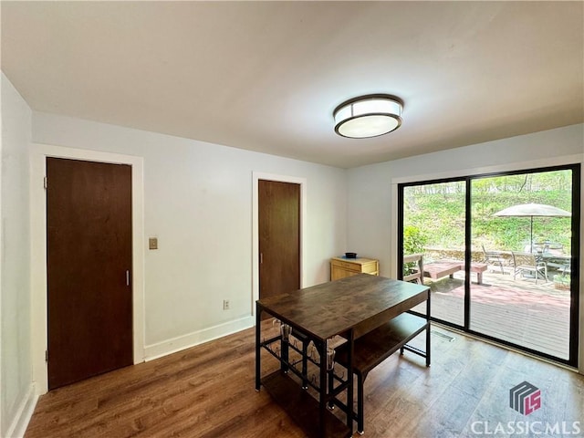 dining space featuring wood finished floors and baseboards